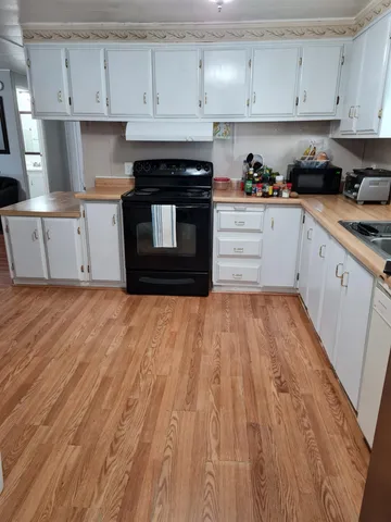 a kitchen with wooden floors and appliances