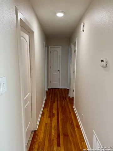 a view of a hallway with wooden floor