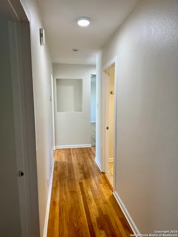 a view of hallway with wooden floor