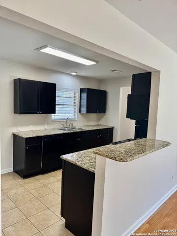 a kitchen with stainless steel appliances kitchen island granite countertop a refrigerator and a stove top oven