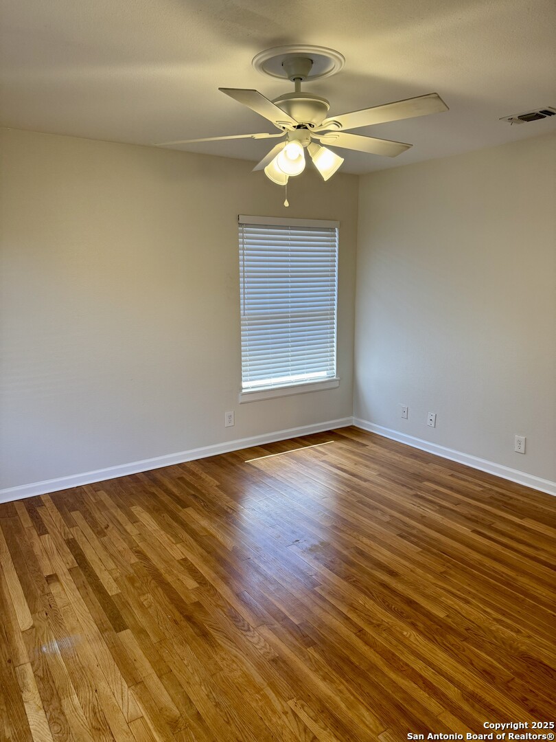 410 Shannon Lee Street San Antonio, TX 78216 - Photo 10 of 19 a view of an empty room with wooden floor and a window