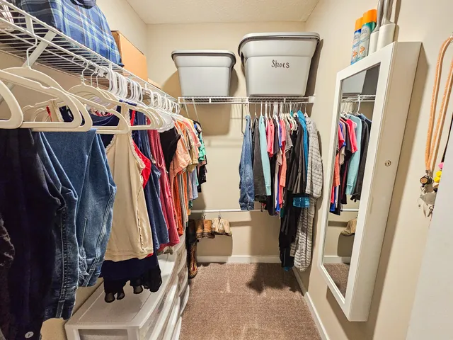 a view of walk in closet with clothes