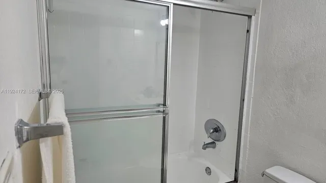 a bathroom with a sink vanity granite toilet and a mirror