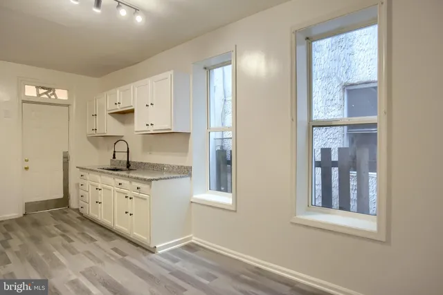 a kitchen with granite countertop white cabinets and white appliances