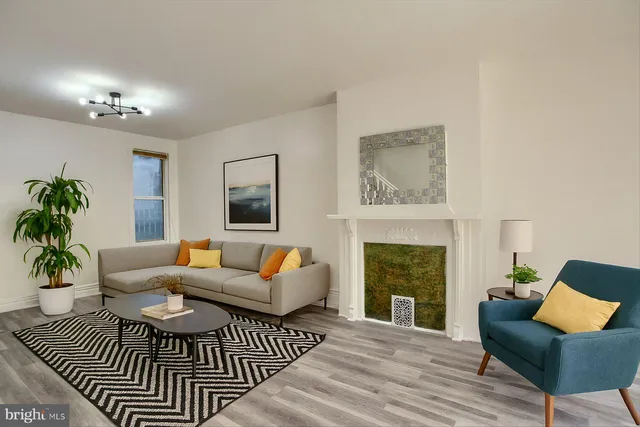 a living room with furniture a fireplace and a potted plant