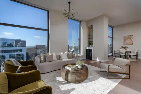 a living room with furniture and large windows