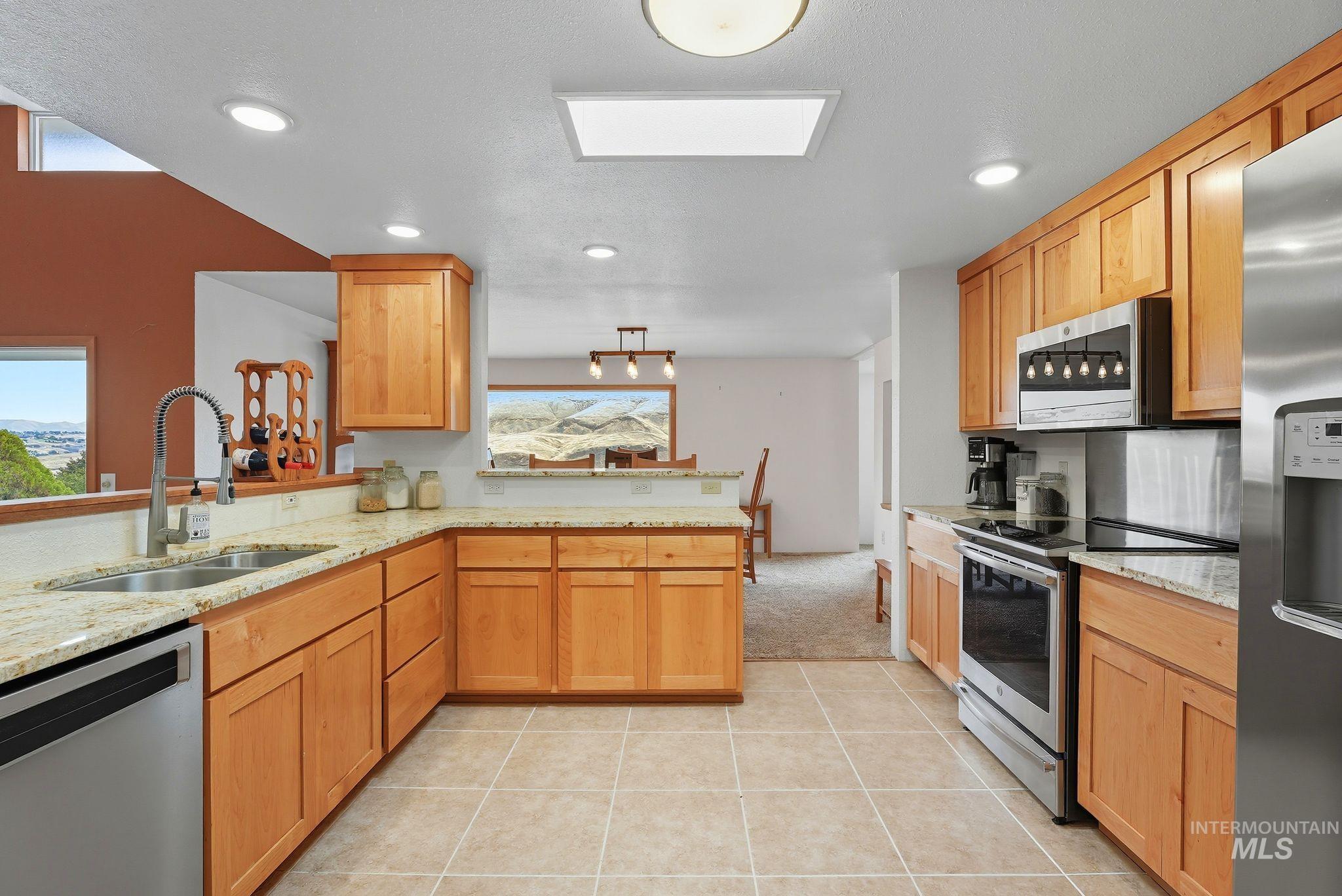 1101 5th Street Asotin, WA 99402 - Photo 14 of 48 Kitchen with appliances with stainless steel finishes, light stone counters, light tile patterned flooring, recessed lighting, and a peninsula