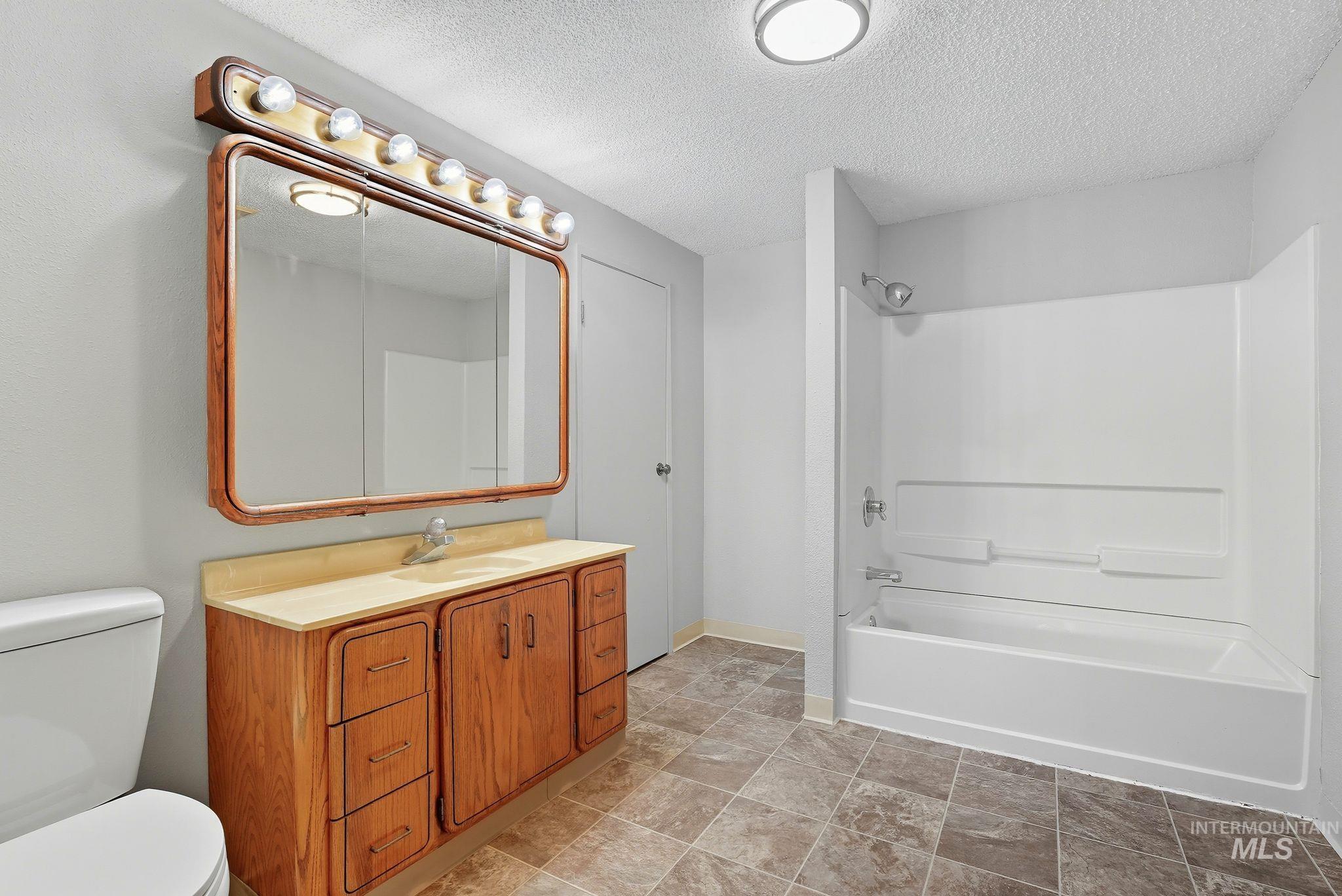 1101 5th Street Asotin, WA 99402 - Photo 24 of 48 Full bath featuring shower / bath combination, a textured ceiling, and vanity