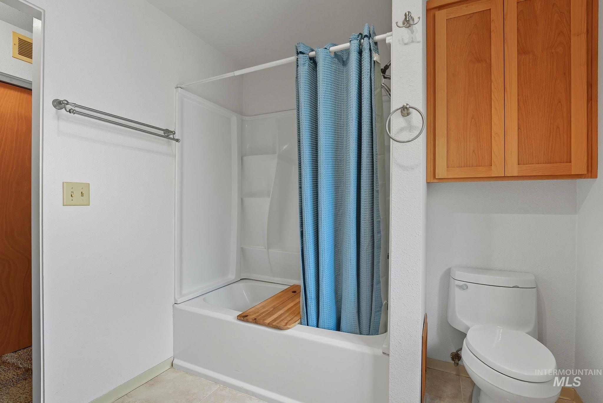 1101 5th Street Asotin, WA 99402 - Photo 28 of 48 Full bath featuring shower / tub combo with curtain and light tile patterned flooring