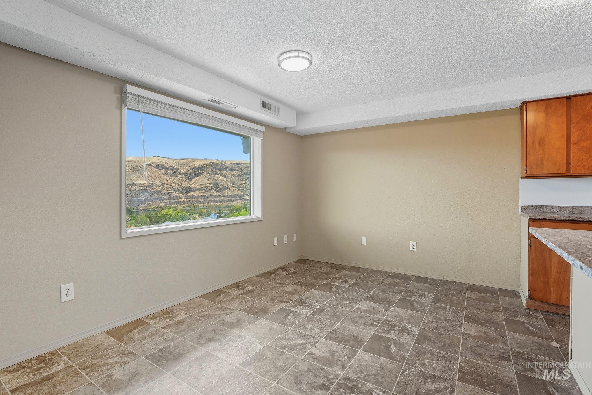 1101 5th Street Asotin, WA 99402 - Photo 33 of 48 Unfurnished dining area with a textured ceiling and stone finish floors