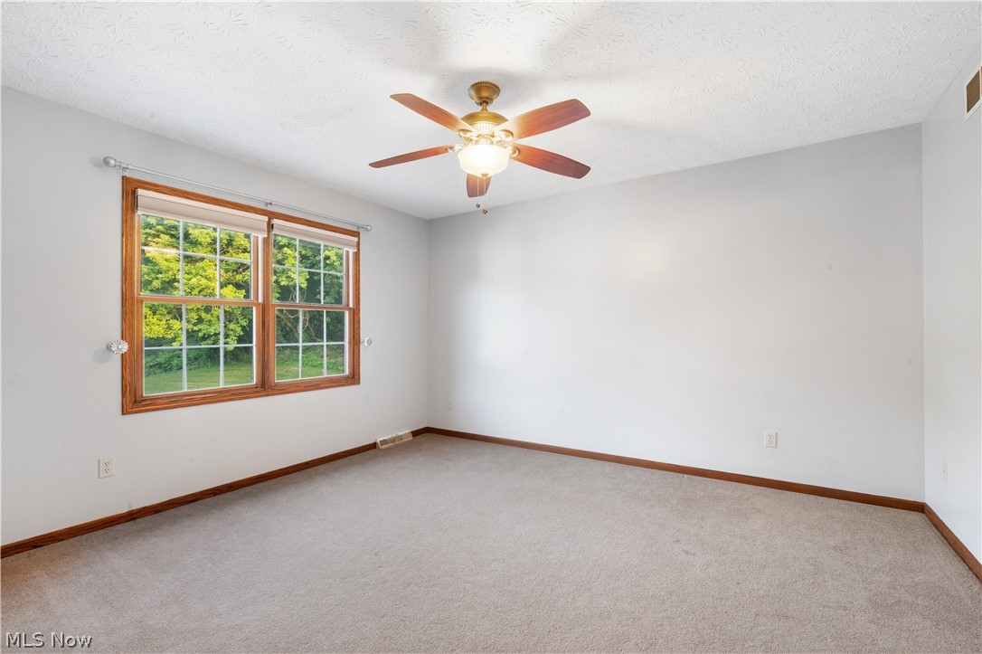 1239 Congress Lake Road Mogadore, OH 44260 - Photo 21 of 35 Carpeted spare room featuring a textured ceiling and ceiling fan