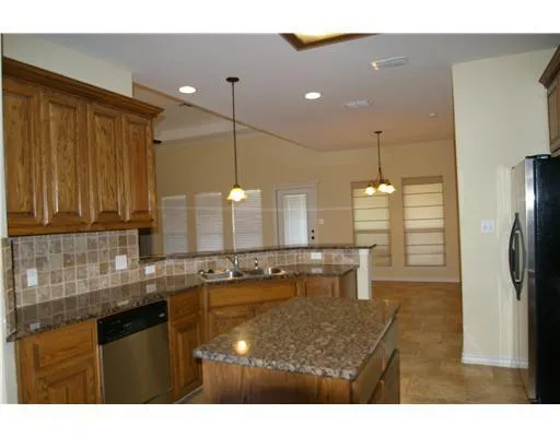 a kitchen with stainless steel appliances granite countertop a sink refrigerator and cabinets