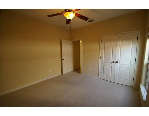 a view of empty room with ceiling fan