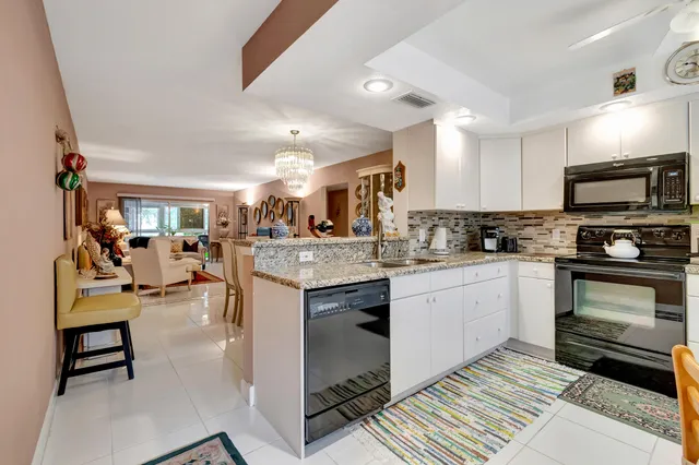 a kitchen with stainless steel appliances granite countertop a stove refrigerator and cabinets
