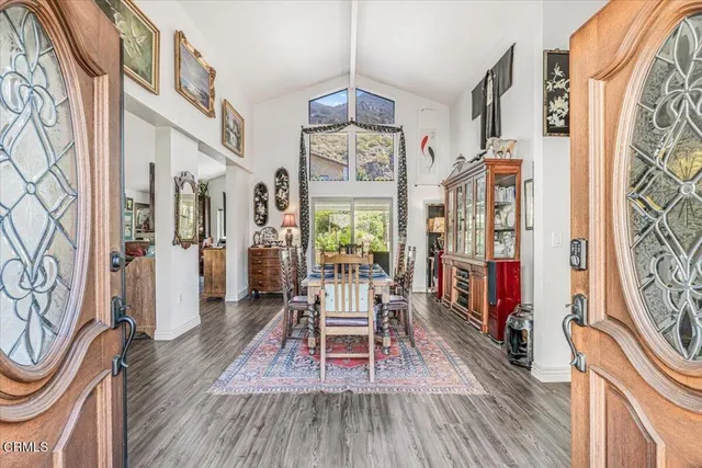 a dining room with wooden floor fireplace and a chandelier