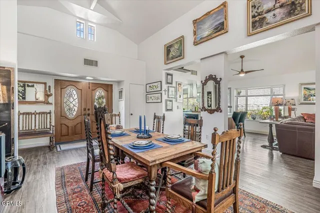 a view of a dining room with furniture a rug and wooden floor