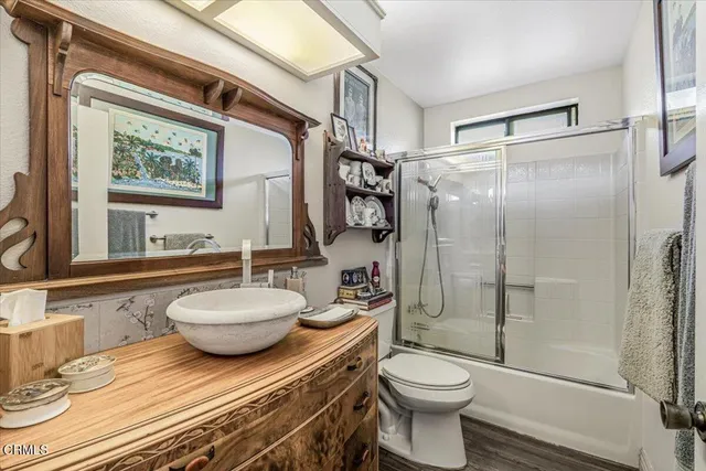 a bathroom with a granite countertop sink toilet a mirror and shower