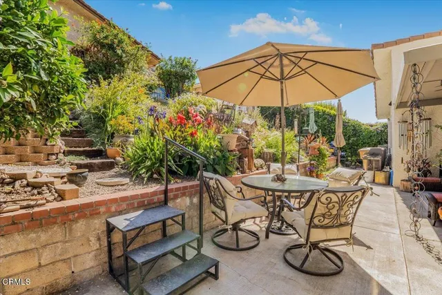 a patio with a table and chairs under an umbrella