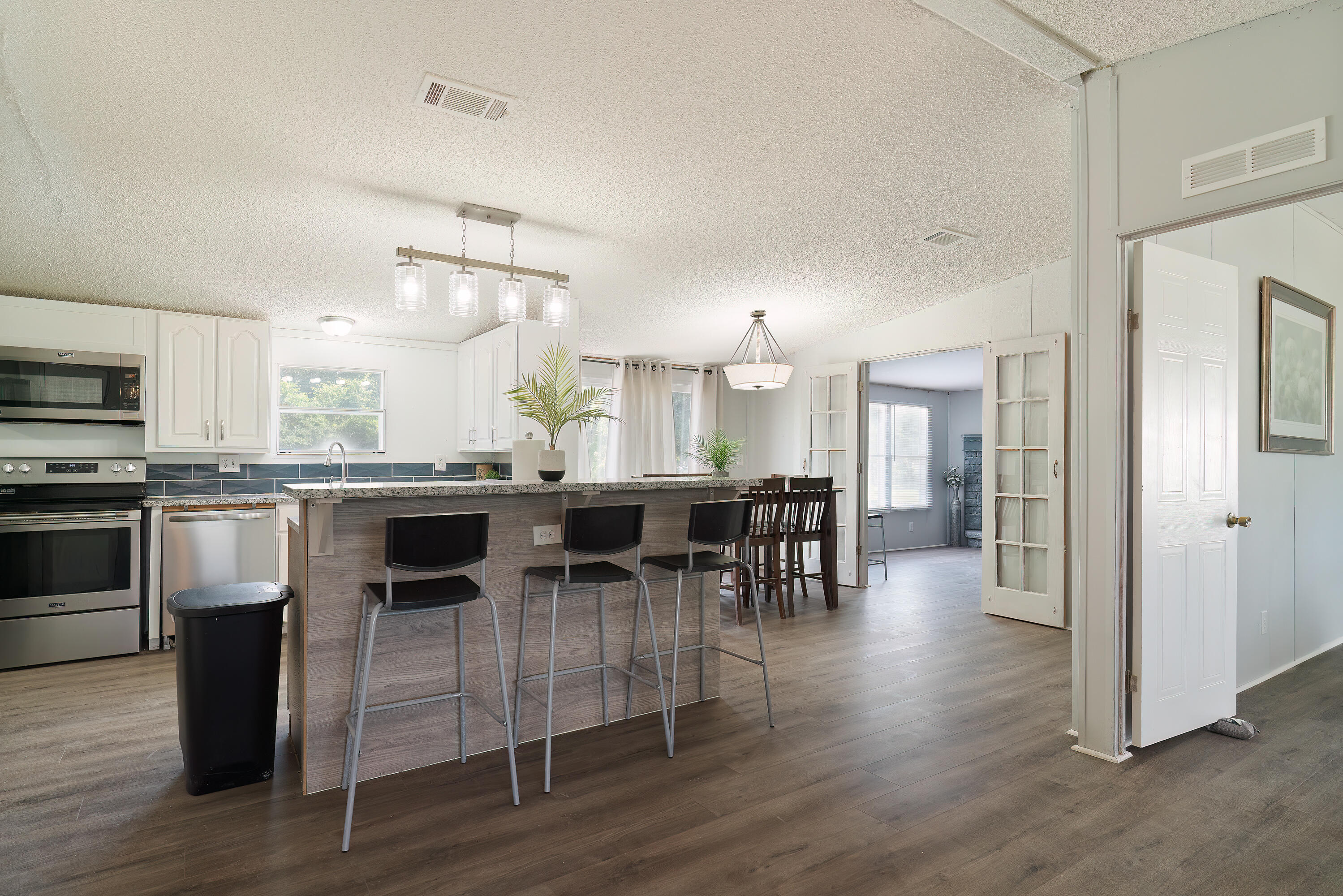 1032 Whitehead Drive Holt, FL 32564 - Photo 5 of 40 a kitchen with stainless steel appliances granite countertop a stove top oven a sink dishwasher a dining table and chairs with wooden floor