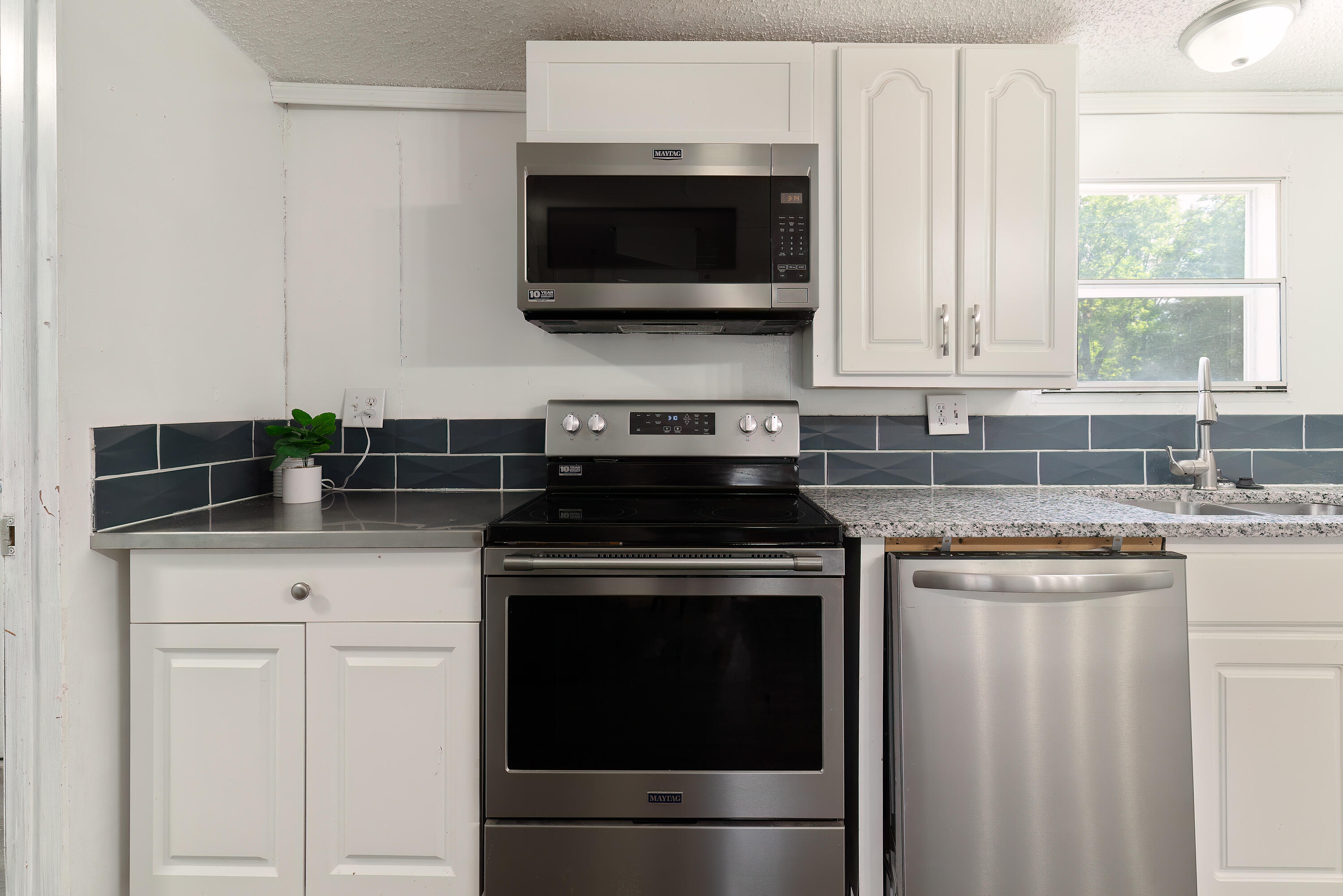 1032 Whitehead Drive Holt, FL 32564 - Photo 10 of 40 a kitchen with stainless steel appliances granite countertop white cabinets and a stove top oven