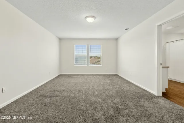 an empty room with windows and closet