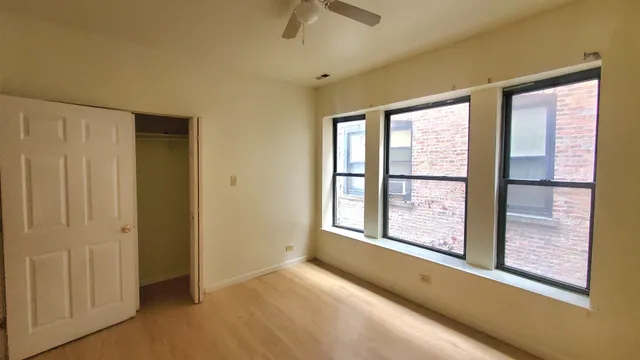 an empty room with windows and closet