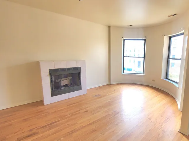 an empty room with windows and fireplace