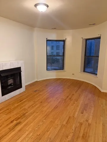 a view of an empty room with a fireplace and a window