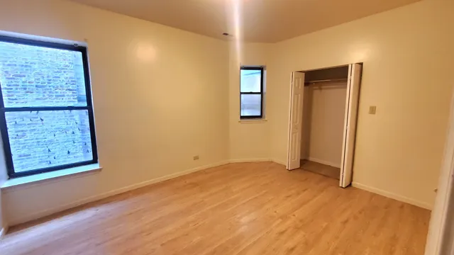 an empty room with windows and closet