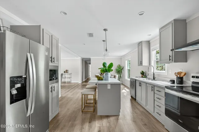 a dining room with furniture potted plants and wooden floor
