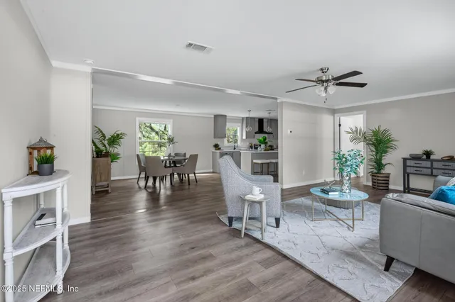 a view of a livingroom with furniture a ceiling fan and wooden floor