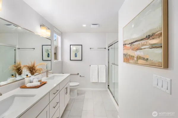 a bathroom with a double vanity sink toilet and a mirror