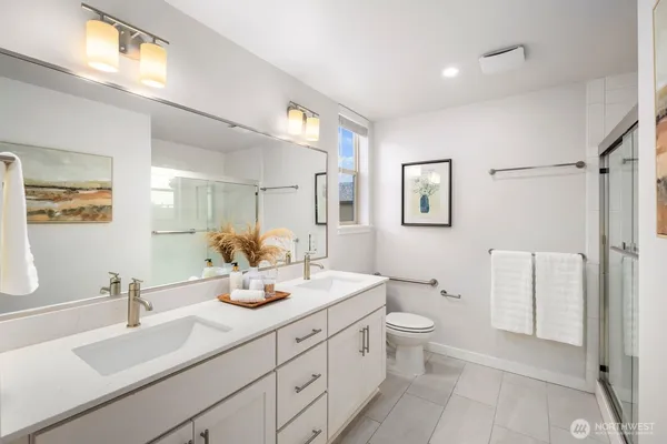 a bathroom with a double vanity sink toilet and a mirror