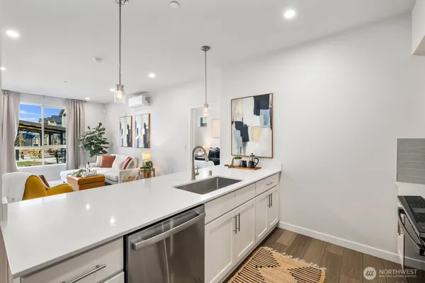 a view of a kitchen counter space a sink a refrigerator and windows