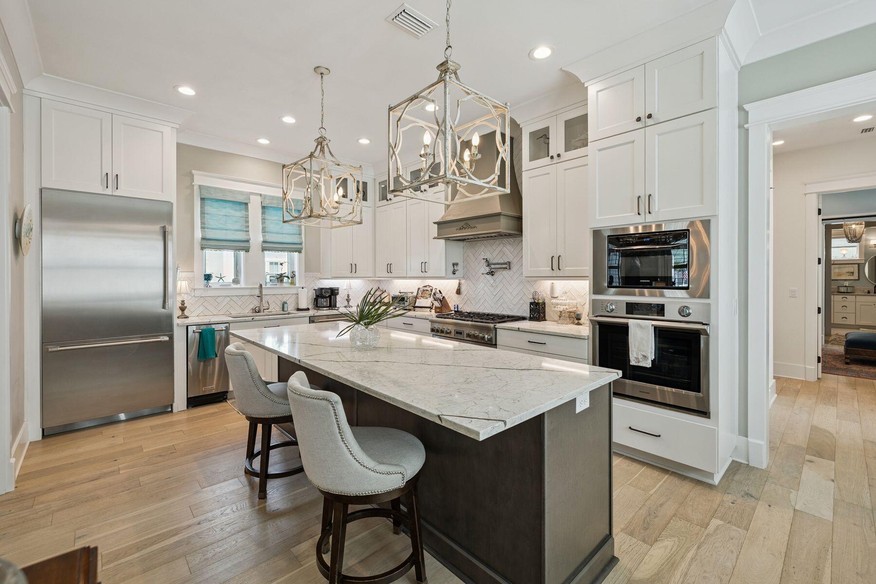 113 White Cliffs Drive Santa Rosa Beach, FL 32459 - Photo 4 of 38 a kitchen with stainless steel appliances granite countertop a sink a stove a refrigerator and island with wooden floor