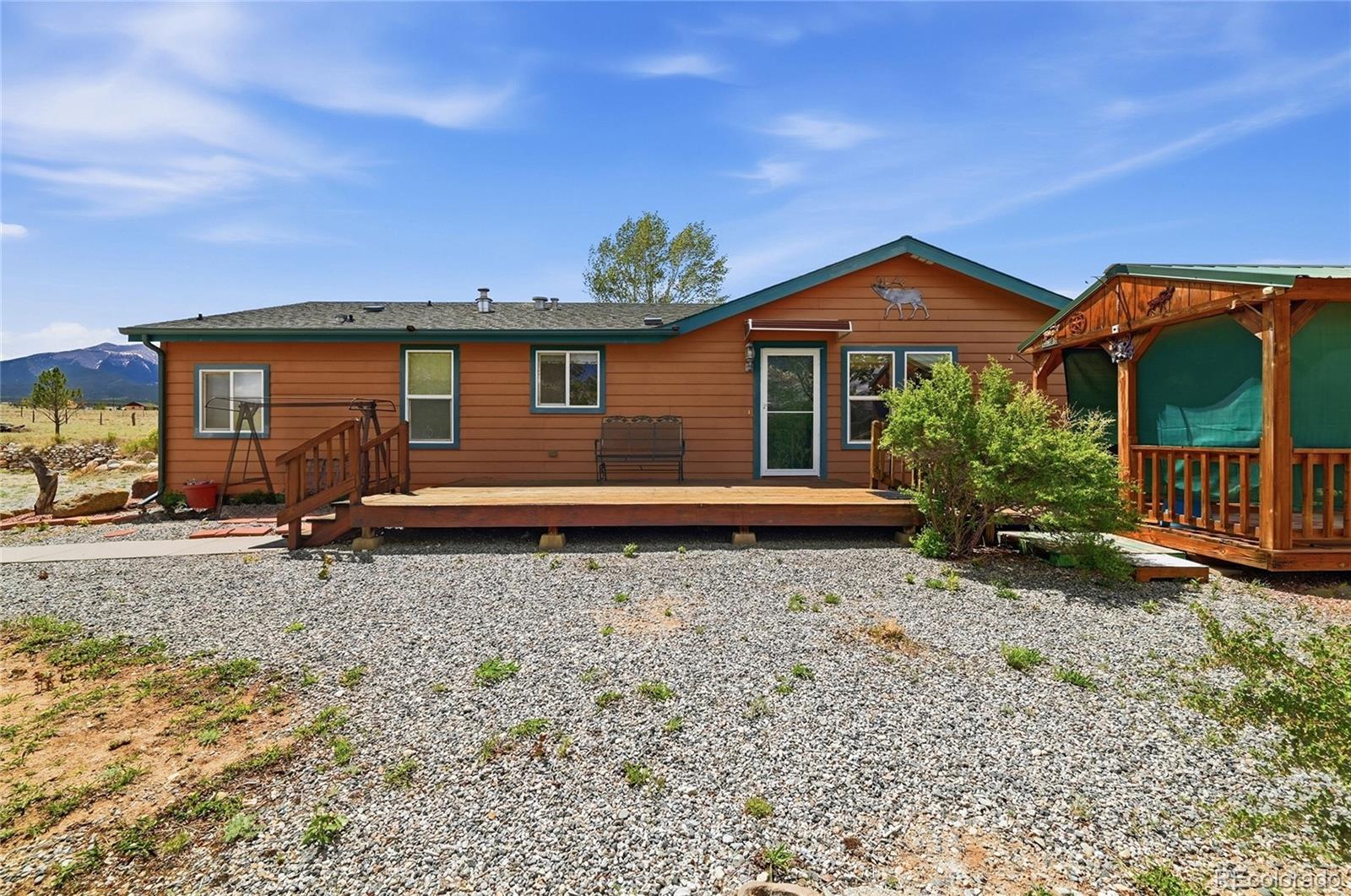 20300 Old Ranch Loop Nathrop, CO 81236 - Photo 1 of 35 a backyard of a house with potted plants and wooden fence