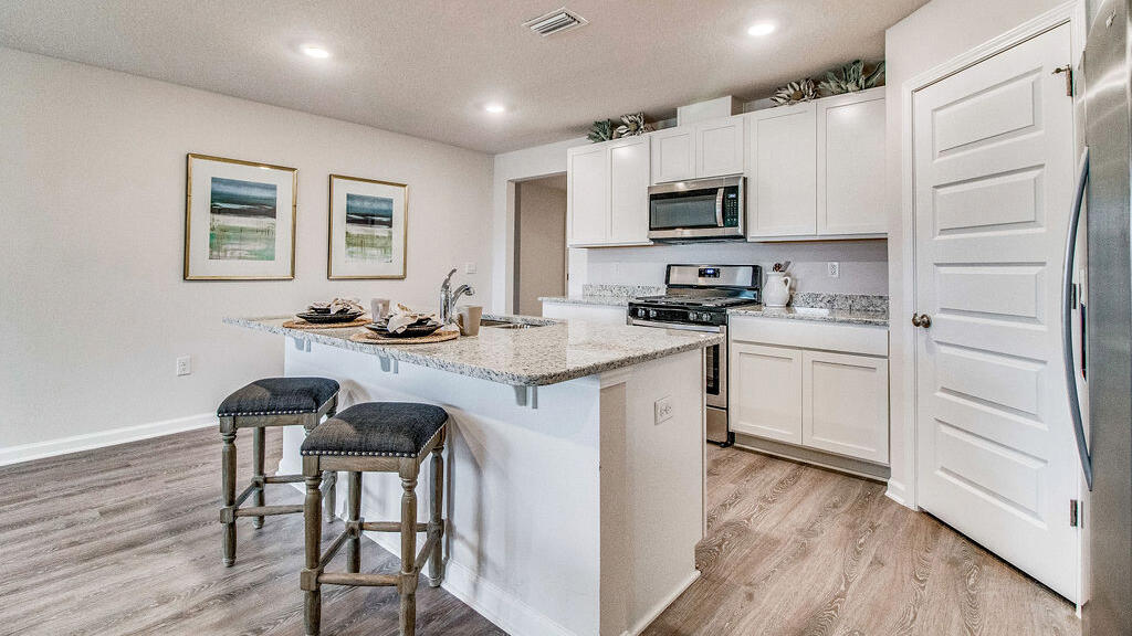 3409 Phoenix Court Crestview, FL 32539 - Photo 4 of 38 a kitchen with granite countertop white cabinets and stainless steel appliances