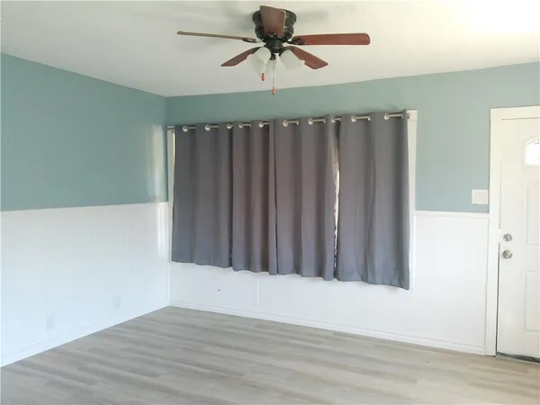 a view of a room with a wooden floor and fan