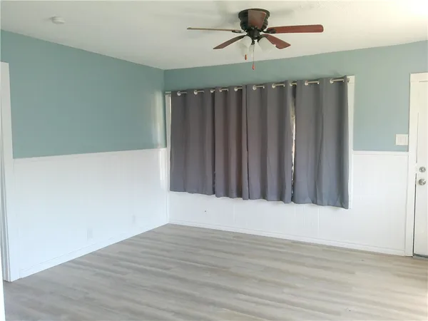 a view of an empty room with wooden floor