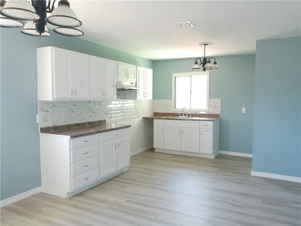 a kitchen with stainless steel appliances granite countertop a white cabinets and wooden floor