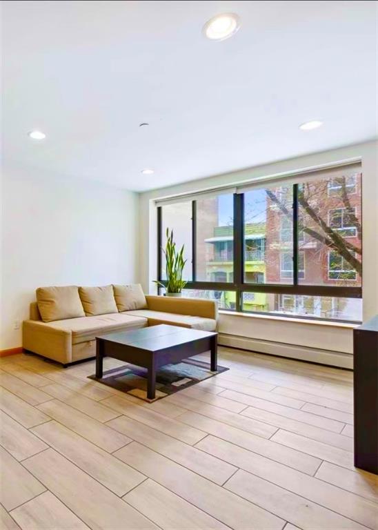 229 55th Street, Unit 2A Brooklyn, NY 11220 - Photo 2 of 12 a living room with furniture and large windows