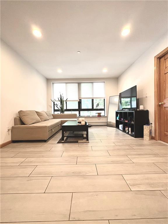 229 55th Street, Unit 2A Brooklyn, NY 11220 - Photo 4 of 12 a living room with furniture and a flat screen tv