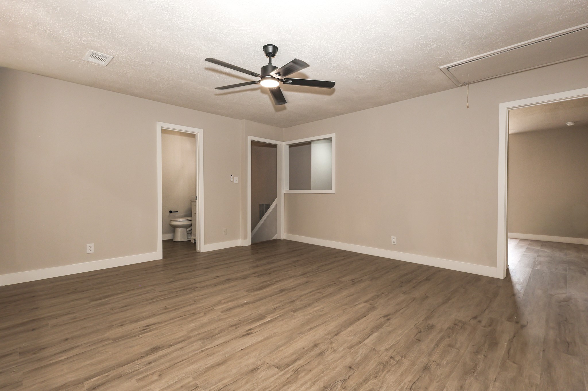 20719 Burnt Amber Lane Houston, TX 77073 - Photo 23 of 32 a view of an empty room with wooden floor and a ceiling fan