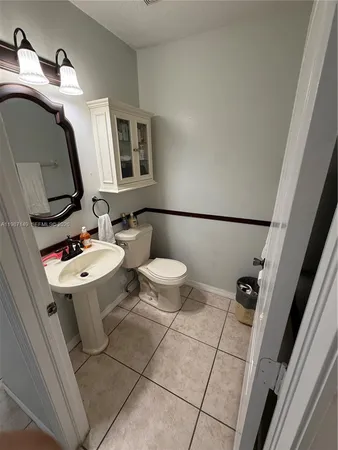 a bathroom with a toilet a sink and mirror