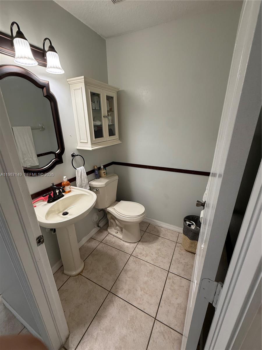 18164 Southwest 149th Place Miami, FL 33187 - Photo 10 of 30 a bathroom with a toilet a sink and mirror