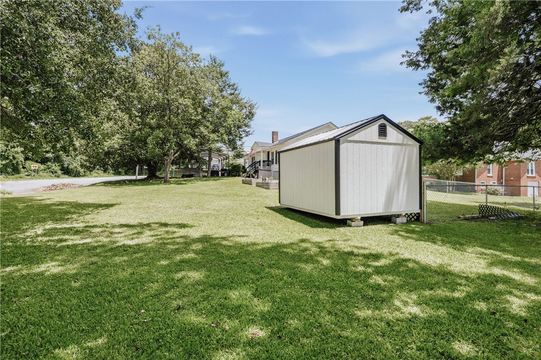 310 North Chestnut Street Seneca, SC 29678 - Photo 5 of 30 A detached shed offers practical backyard storage alongside a lush green lawn.
