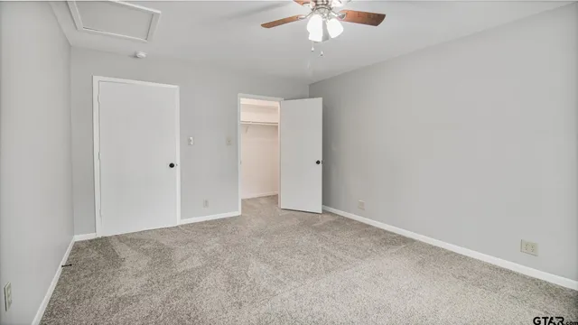 an empty room with a chandelier fan