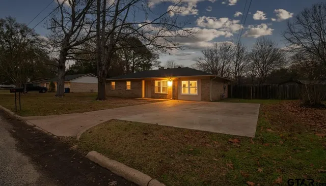 a view of house with backyard and tree