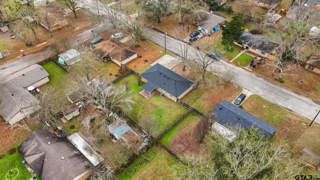 an aerial view of a house with a yard and lake view