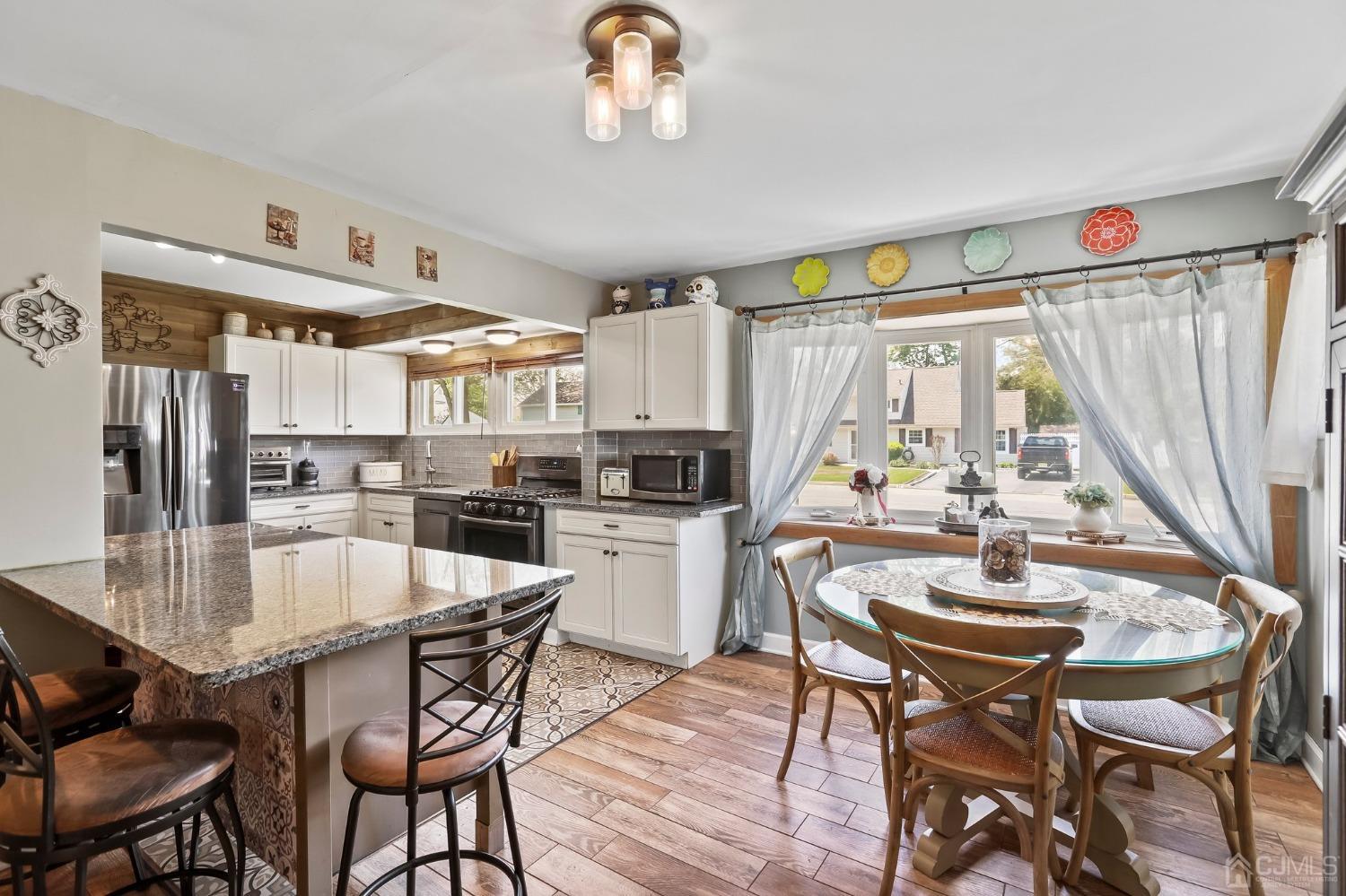 26 Sunrise Road Old Bridge, NJ 08857 - Photo 10 of 33 a kitchen with stainless steel appliances granite countertop a stove a refrigerator a kitchen island a table and chairs
